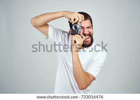 photographer takes pictures on the camera on a light background                               
