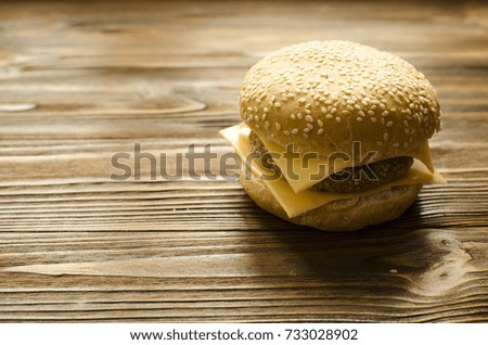 Cheeseburger on wooden background with space for text