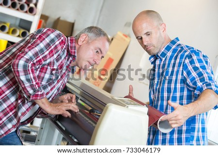 workers checking a printer format inkjet working