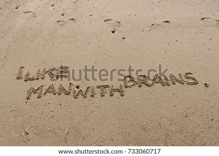 Handwriting  words "I LIKE MAN WITH BRAINS." on sand of beach.