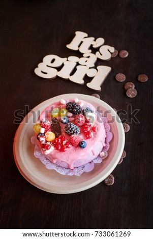 Sweet cheese cake with fresh berries and yoghurt cream and wooden sign Its A Girl. Baby shower party sweets.