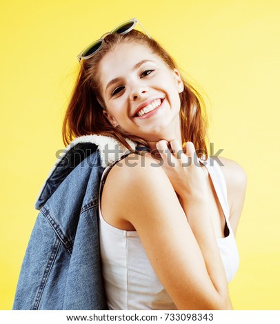 young pretty teenage woman happy smiling posing on yellow background, fashion lifestyle people concept 