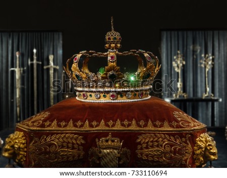 Gold and jewell-studded King's crown on a ceremonial pillow                                Royalty-Free Stock Photo #733110694