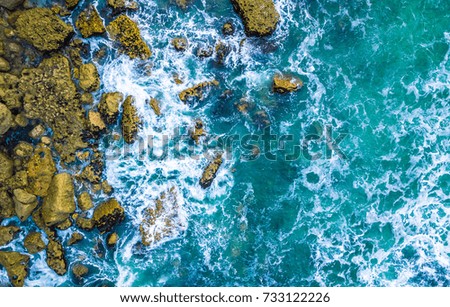 Drone view of waves hitting sea shore and rocks