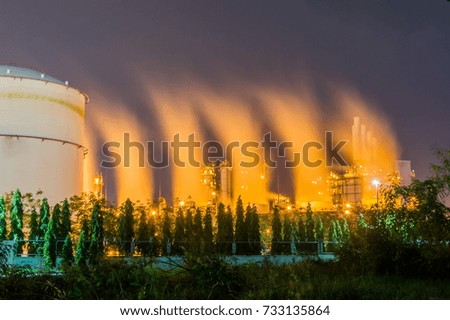oil and gas refinery industrial plant and smoke steam at night.