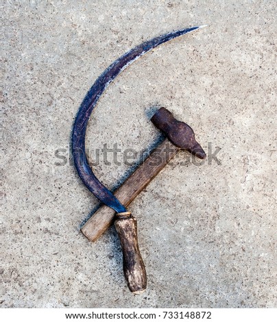 Sickle and hammer (serp i molot). Farm and worker tools on the concrete surface.
