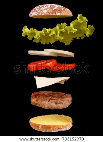 Burger parts flying in air isolated on black Royalty-Free Stock Photo #733152970