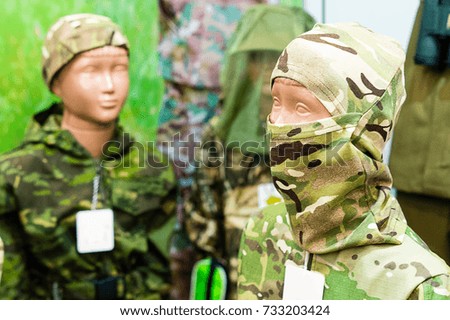 Camouflage suit for children. A boy in a balaclava is a mannequin.