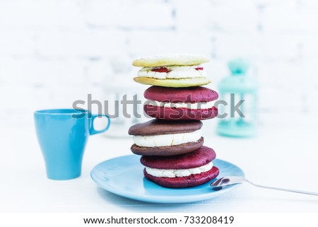 Stack of four whoopie pies or moon pies with cup and spoon.