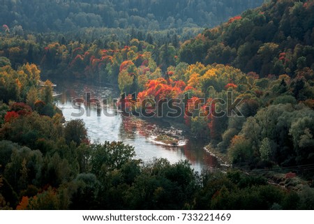 Picturesque view on valley of Gaujas national park. Trees changing colors in foothills.  Colorful Autumn day at city Sigulda in Latvia. 

 Royalty-Free Stock Photo #733221469