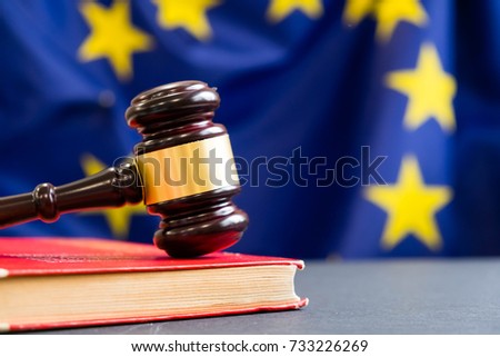 Judges wooden gavel with EU flag in the background. Symbol for jurisdiction. Wooden gavel on european union flag Royalty-Free Stock Photo #733226269