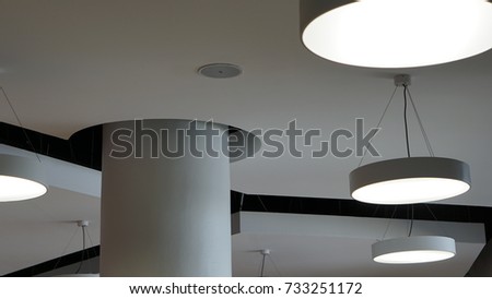 Modern chandelier hanging under ceiling.