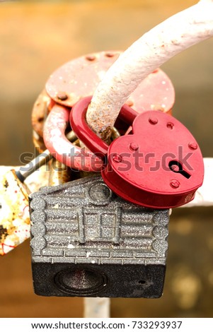 Heart lock hanging on the iron fence of an old rusty red new glossy love family wedding house tradition