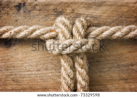 Rope with knots on the background of the old wooden boards