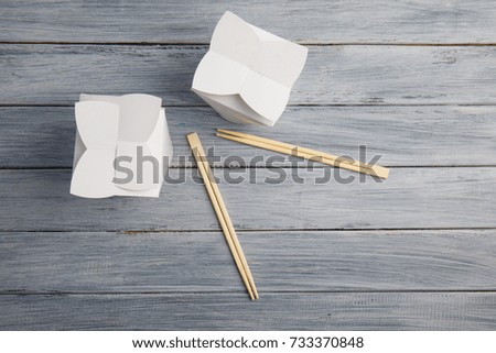 Boxes from under Chinese food on a wooden gray table.