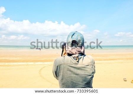 Hipster woman take photo on the beach, girl takes picture on her camera while walking along the beach, woman having leisure time walking on beach during summer holding  photography camera.