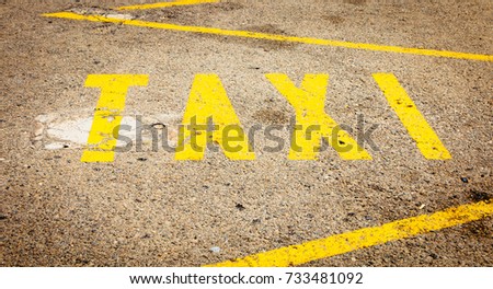 yellow paint on the dirty road that indicates a taxi line