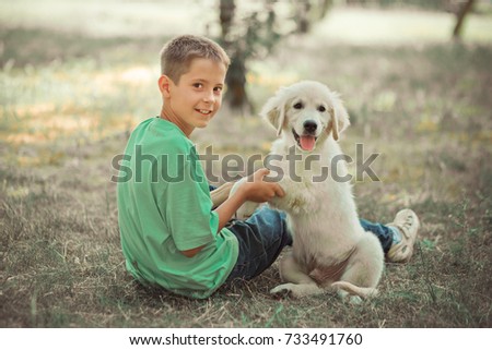 Retriever pup Lovely scene handsome teen boy enjoying summer time vacation with best friend dog ivory white labrador puppy.Happy airily careless childhood life in world of dreams.