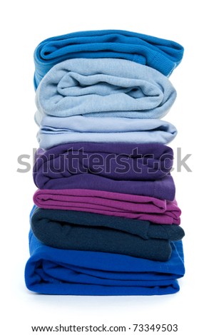 Fresh laundry. Pile of blue and purple folded clothes on white background.