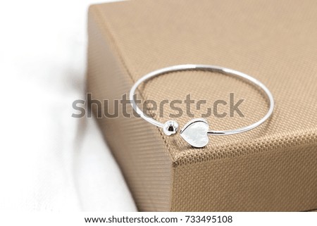 Close up shot of beautiful silver bracelet with heart background