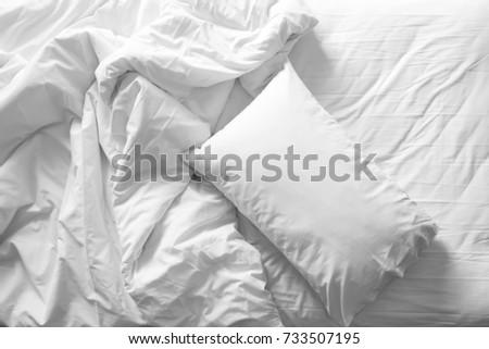 Messy bed. White pillow with blanket on bed unmade. Concept of relaxing after morning. With lighting window. Top view. Black and white theme. Royalty-Free Stock Photo #733507195