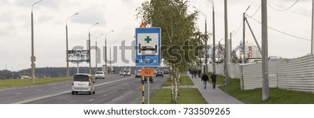sign of the hospital on the road with cars