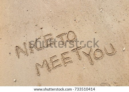 Handwriting  words "NICE TO MEET YOU" on sand of beach. Royalty-Free Stock Photo #733510414