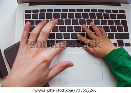 Close-up hands of man and child on keyboard of laptop indoors Royalty-Free Stock Photo #733515268
