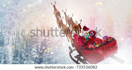 High angle view of Santa Claus riding on sled with gift box against snowy pine trees on alp mountain slope