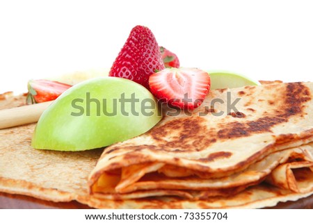 dessert : thin round pancake with honey strawberries and apple isolated over white background