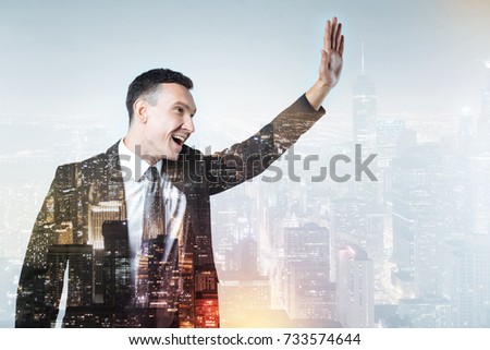 Cheerful man in black suit waving to his friends