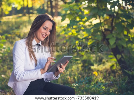 Woman smiling and using touchpad outdoors,nature is my office.