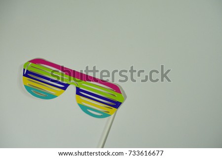 Top or flat lay view of birthday props, colorful stripe spectacles on isolated white background. Birthday parties text and props.