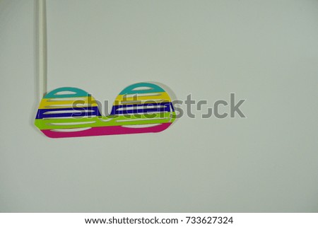 Top or flat lay view of birthday props, colorful stripe spectacles on isolated white background. Birthday parties text and props.