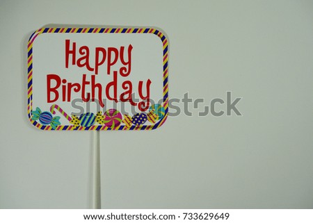 Top or flat lay view of birthday props, a signboard with wording Happy Birthday on isolated white background. Birthday parties text and props.