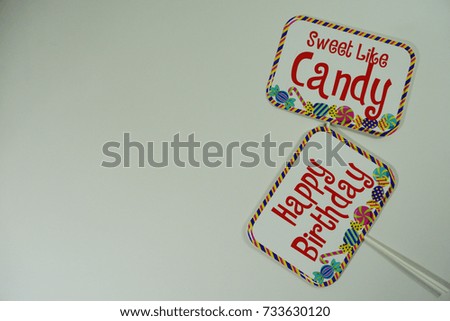 Top or flat lay view of birthday props, a signboard with wording Happy Birthday and Sweet Like Candy on isolated white background. Birthday parties text and props.
