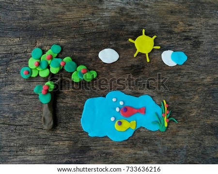 Beautiful natural clay plasticine,tree,sky and sea on wooden background,colorful dough