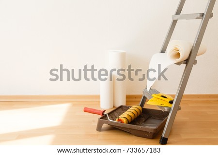 Wallpaper gluing in a room. Tools for gluing white wallpapers. White room after renovation. Fresh repair in a room Royalty-Free Stock Photo #733657183