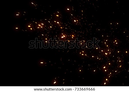 Random flying fire sparks particles isolated on the black background for overlay design. Royalty-Free Stock Photo #733669666