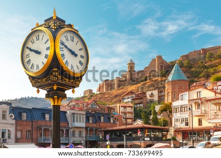 Amazing view of City clock, Old Meidan Square and Narikala ancient fortress in the sunny morning, Tbilisi, Georgia. Royalty-Free Stock Photo #733699495
