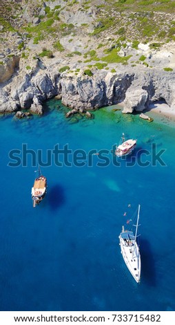 Summer 2017: Aerial birds eye view photo taken by drone of rocky tropical beach with yachts docked and turquoise clear waters