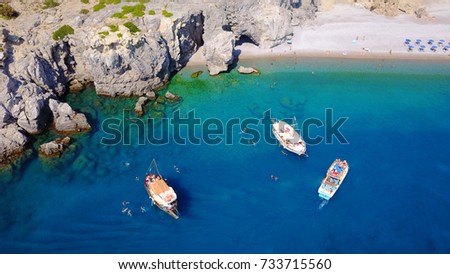 Summer 2017: Aerial birds eye view photo taken by drone of rocky tropical beach with yachts docked and turquoise clear waters