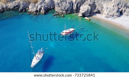 Aerial bird's eye view photo taken by drone of boats docked in caribbean tropical beach with turquoise - sapphire waters