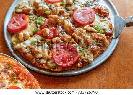 Delicious fresh pizza served on wooden table, brown background.