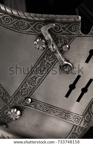 Details medieval knightly Italian helmet Armet on a black background.