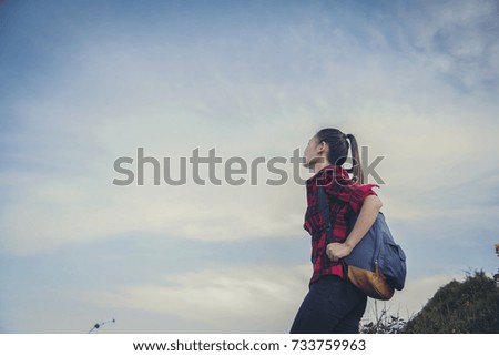 Hipster young girl with backpack enjoying sunset on peak of foggy mountain. Tourist traveler on background view mockup. Hiker looking sunlight in trip