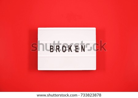 Broken text in black and white on light box message sign board on red background