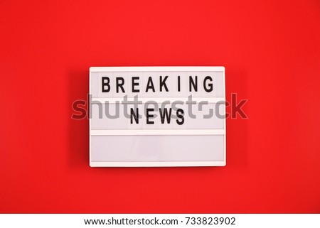 Breaking news text in black and white on light box message sign board on red background