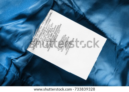 Fabric composition and washing instructions clothes label on blue textile background