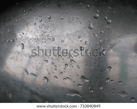 Monsoon rain drops on the stainless steel texture. 